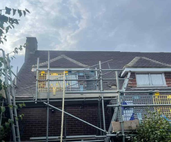 This is a photo of a roof with two dormers that is having some damaged tiles replaced. Works carried out by BMT Roofing Wollaston